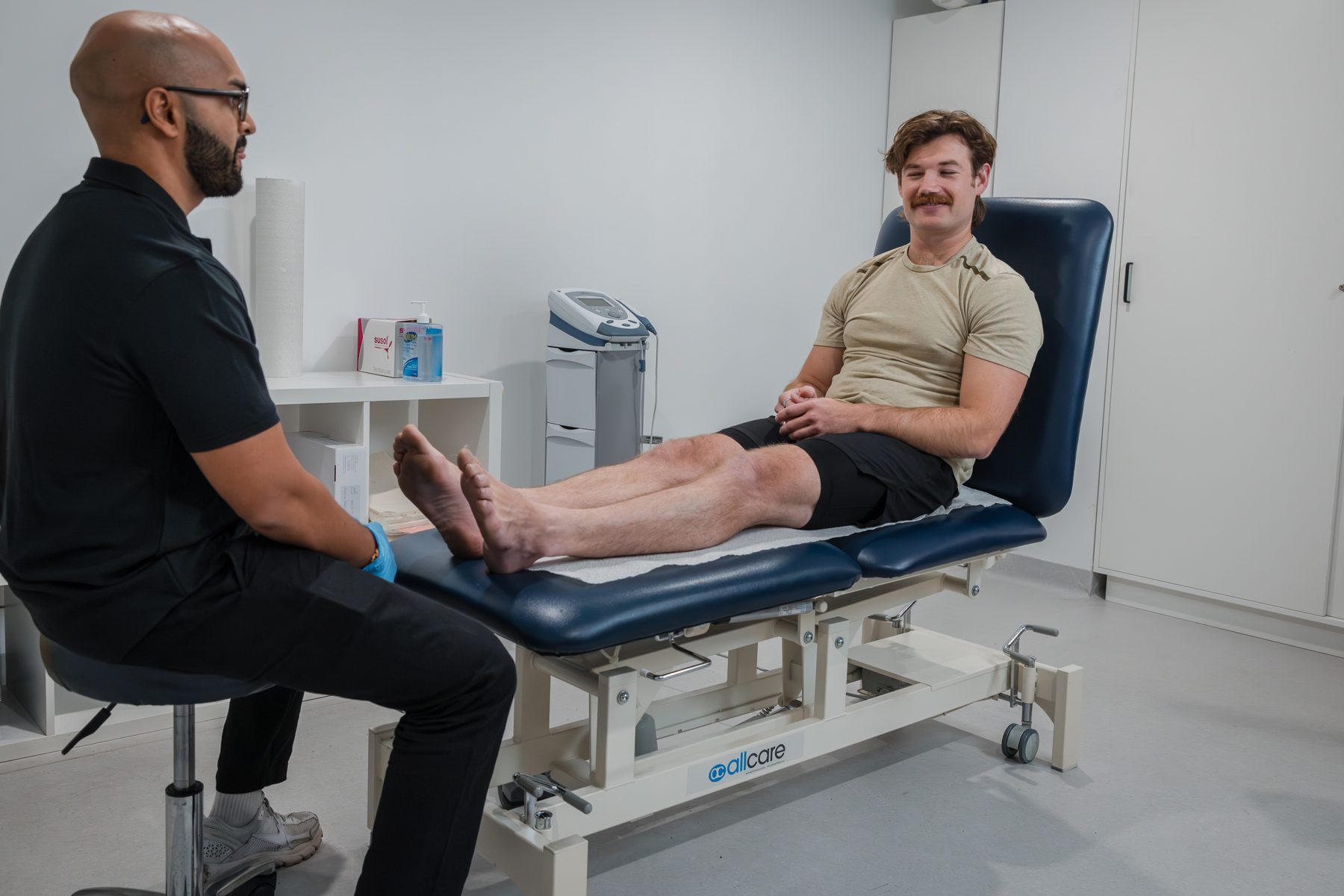 Physiotherapist assessing a client on the treatment table